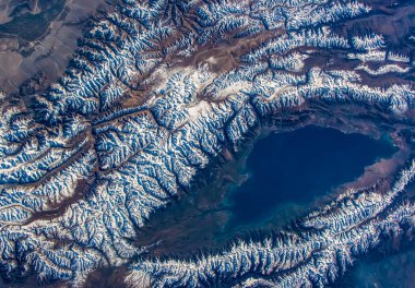 Kırgızistan 'daki Issyk-Kul Gölü' nün havadan görünüşü. Kar Tian Shan dağlarını kapladı. Bu görüntünün elementleri NASA tarafından desteklenmektedir.