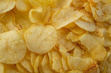 Patates cipsi. Çıtır cipslerin üst görüntüsü. Yemek arkaplanı. Sağlıksız, yağlı, tuzlu atıştırmalıklar..