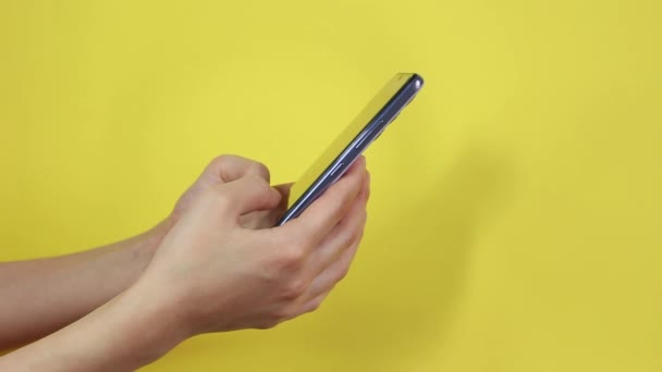 Жінка Використовує Смартфон Жовтому Тлі Рука Тримає Мобільний Телефон Фоні — стокове відео