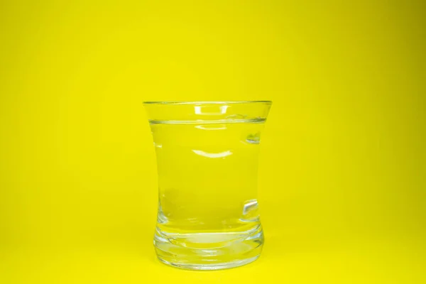 黄色の背景に隔離された水のガラス — ストック写真