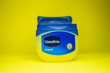 Vaseline bottle on yellow background. Skin care product vaseline or petroleum jelly. Afyonkarahisar, Turkey - November 19, 2022. clipart