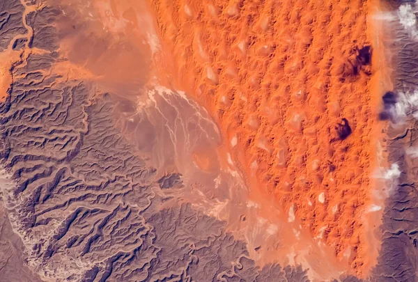 Aerial view of portion of the Sahara Desert in Algeria. Satellite view of sand dunes, sandstone plateaus and rocky platforms. Elements of this image furnished by NASA.