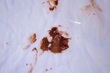 Chocolate stain on white shirt. Top view dirty t shirt.