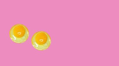 Raw egg yolk stop motion animation on pink background. Uncooked egg.