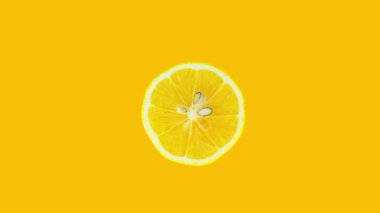 Lemon slice rotating on yellow background. Stop motion citrus animation. Healthy eating and refreshment concept.