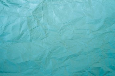 Crumpled blue paper texture background. Wrinkled paper surface for designs.