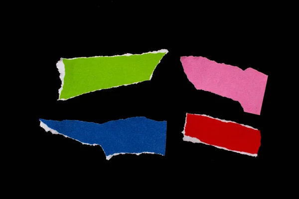 Colorful torn paper pieces isolated on black background. Ripped papers.