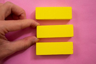 Hand holding empty yellow wooden blocks