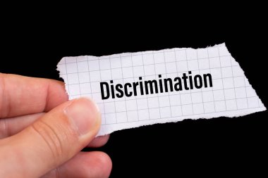 Discrimination word written on ripped paper.