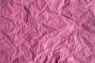 Crumpled pink paper texture background. Wrinkled paper surface for designs.
