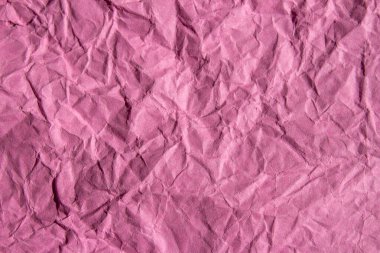 Crumpled pink paper texture background. Wrinkled paper surface for designs.