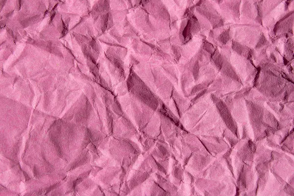 Crumpled pink paper texture background. Wrinkled paper surface for designs.