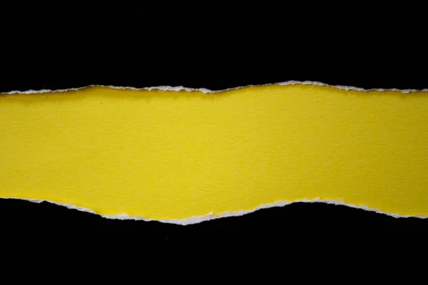 Black torn paper background. Ripped paper on yellow background with copy space.