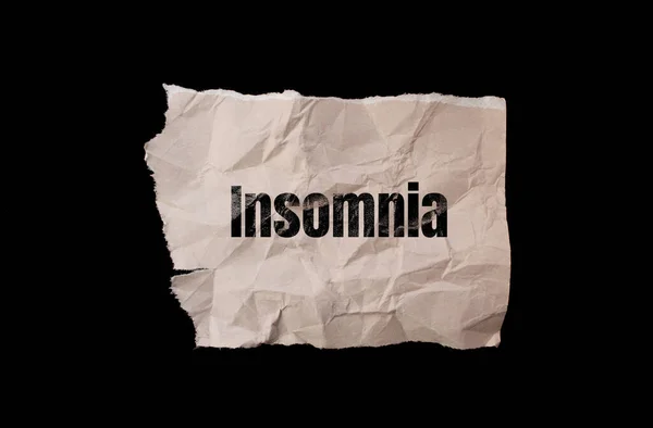 Insomnia word written on paper. Sleep problems concept.
