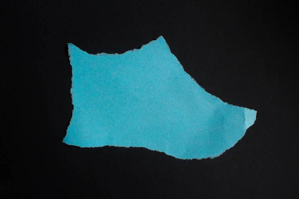 Pieza Papel Desgarrada Azul Aislada Sobre Fondo Negro Papel Blanco —  Fotos de Stock