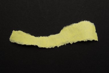 Siyah arka planda geri dönüşümlü sarı kağıt. Metin için kopya alanı olan yırtık kağıt arkaplanı.