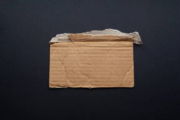 stock image Ripped corrugated cardboard piece on a black background