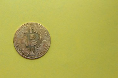 Sarı arka planda izole edilmiş altın bitcoin. Üst görünüm, alanı kopyala.