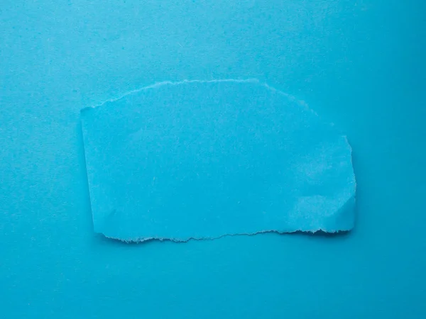 Blue torn paper on a blue background. Copy space for text.