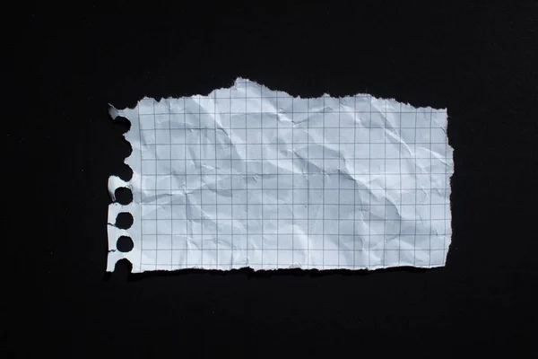 Siyah arkaplan üzerine yırtılmış beyaz grafik kağıdı. Kopyalama alanı olan yırtık kağıt arkaplanı.