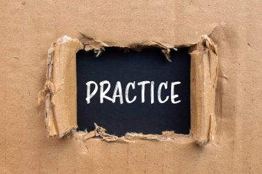 Siyah sırtlı karton kağıda yazılmış kelime alıştırması yap