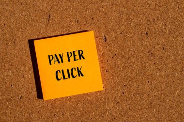 Kahverengi arka planda turuncu kağıt etiketine yazılmış her tıklama sözcüğünü öde. Tıklama başına konsept ödeme sembolü. Boşluğu kopyala.