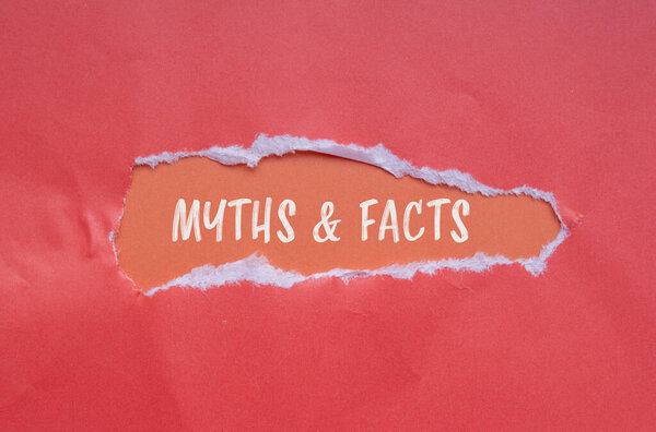 Myths & facts words written on torn paper with orange background. Conceptual myths & facts symbol. Copy space.