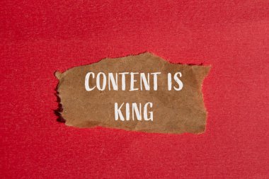 İçerik, kırmızı arkaplanlı yırtık kahverengi kağıt parçasına yazılmış kral kelimeleridir. Kavramsal içerik kral sembolüdür. Boşluğu kopyala.