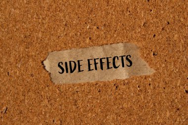 Kahverengi arka planda yırtık kağıt parçasına yazılmış yan etkiler. Kavramsal yan etkiler sembolü. Boşluğu kopyala.