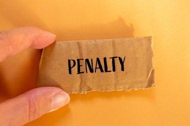 Turuncu arkaplanlı karton kağıt parçasına yazılan ceza sözü. Kavramsal ceza sembolü. Boşluğu kopyala.