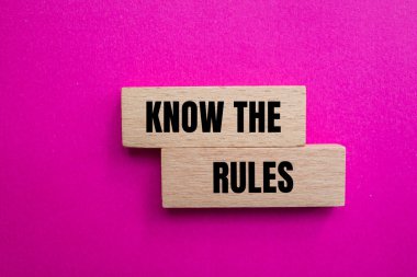 Ahşap bloklara pembe arka planda yazılmış kuralları biliyorsun. Kavramsal olarak kuralları biliyorum. Boşluğu kopyala.