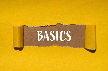 Kahverengi arkaplan ile yırtılmış sarı kağıda yazılmış temel kelime. Kavramsal temel kelime sembolü. Boşluğu kopyala.