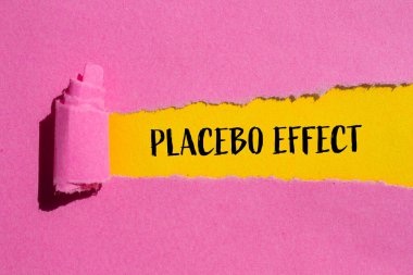 Plasebo efektleri sarı arka planlı pembe kağıda yazılmış. Kavramsal plasebo etkisi sembolü. Boşluğu kopyala.