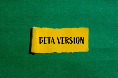 Yeşil arkaplanlı, yırtık sarı kağıda yazılmış Beta versiyonu kelimeler. Kavramsal beta sürüm sembolü. Boşluğu kopyala.