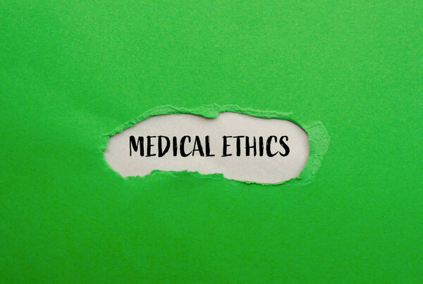 Медицинские этические слова, написанные на разорванной зеленой бумаге с серым фоном. Символ медицинской этики. Копирование пространства.