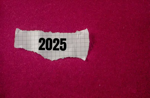 2025 Geschrieben Auf Zerrissenem Papierstück Mit Violettem Hintergrund Konzeptionelles Neujahrssymbol lizenzfreie Stockbilder