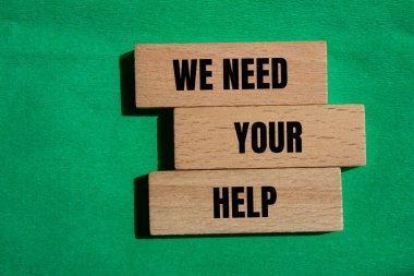 Tahta bloklara yeşil arkaplan ile yazılmış yardım sözlerinize ihtiyacımız var. Kavramsal olarak yardım sembolüne ihtiyacımız var. Boşluğu kopyala.