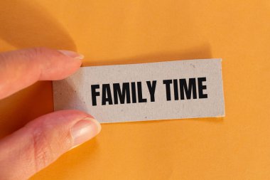 Turuncu arkaplanlı yırtık kağıt parçasına yazılmış aile zamanı mesajı. Kavramsal aile zaman sembolü. Boşluğu kopyala.