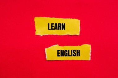 Kırmızı arkaplanlı yırtık sarı kağıt parçalarına İngilizce mesaj yazmayı öğren. Kavramsal İngilizce öğrenme sembolü. Boşluğu kopyala.