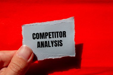 Kırmızı arkaplanlı yırtık kağıt parçasına yazılmış rakip analiz mesajı. Kavramsal rakip analiz sembolü. Boşluğu kopyala.