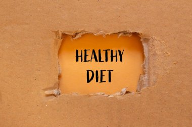 Turuncu arkaplanlı karton kağıda yazılmış sağlıklı diyet mesajı. Kavramsal sağlıklı diyet sembolü. Boşluğu kopyala.