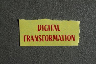 Gri arkaplanlı sarı kağıt parçasına dijital dönüşüm mesajı yazılmış. Kavramsal dijital dönüşüm sembolü. Boşluğu kopyala.