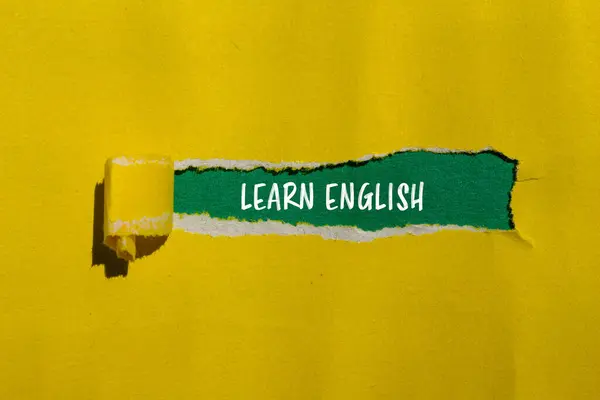 stock image Learn english message written on ripped yellow paper with green background. Conceptual learn english symbol. Copy space.