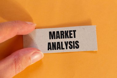 Turuncu arka planlı yırtık kağıt parçasına yazılmış pazar analizi mesajı. Kavramsal pazar analizi sembolü. Boşluğu kopyala.