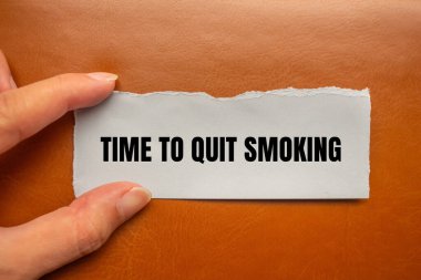 Kahverengi arka planda yırtık kağıt parçasına yazılmış sigara içme mesajını bırakma zamanı. Sigara içmeyi bırakmanın kavramsal zamanı. Boşluğu kopyala.