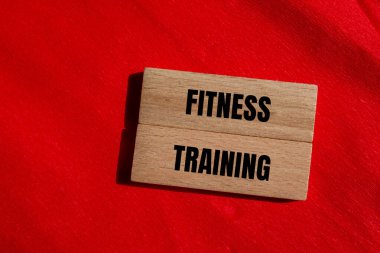 Tahta bloklara kırmızı arka planlı fitness eğitimi mesajı yazılmış. Kavramsal fitness eğitim sembolü. Boşluğu kopyala.