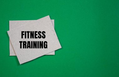 Yeşil arkaplanlı kağıt parçasına spor eğitimi mesajı yazılmış. Kavramsal fitness eğitim sembolü. Boşluğu kopyala.