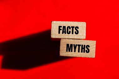 Ahşap bloklara kırmızı arka planda yazılmış gerçekler ve efsaneler. Kavramsal gerçekler ve mitler sembolü. Boşluğu kopyala.