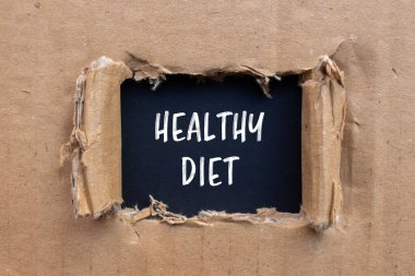 Siyah arkaplanlı karton kağıda yazılmış sağlıklı diyet mesajı. Kavramsal sağlıklı diyet sembolü. Boşluğu kopyala.