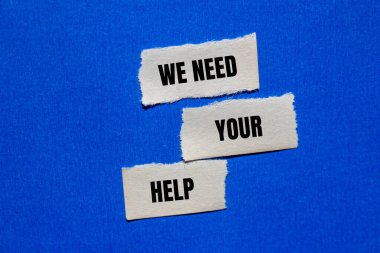 Mavi arka planda yırtık kağıt parçalarına yazılı yardım mesajına ihtiyacımız var. Kavramsal olarak yardım sembolüne ihtiyacımız var. Boşluğu kopyala.